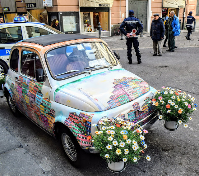 masina vintage cu flori si cladiri pictate in genova italia